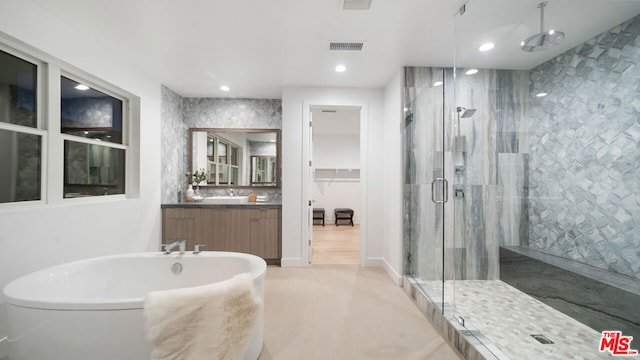 bathroom with vanity and independent shower and bath