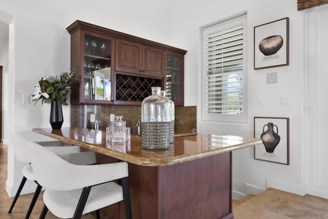 bar with backsplash and dark brown cabinets