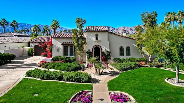 mediterranean / spanish-style house featuring a garage, a mountain view, and a front yard