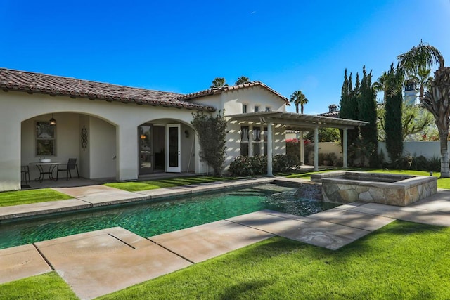 back of house featuring a lawn, a swimming pool with hot tub, a pergola, and a patio