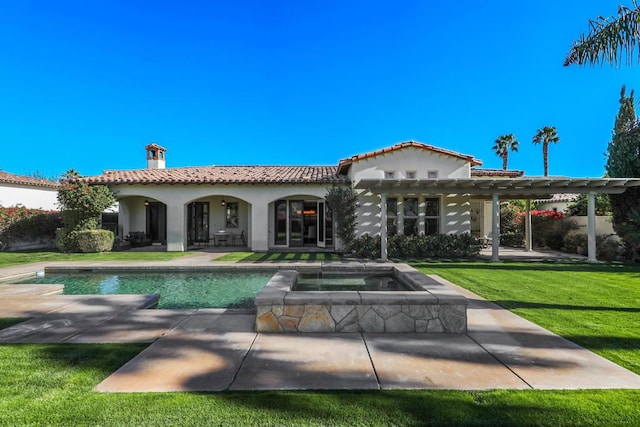 back of house featuring a pool with hot tub, a lawn, a pergola, and a patio