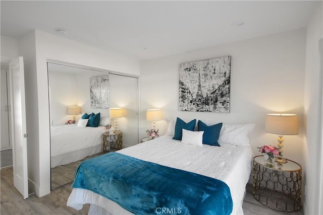 bedroom with light hardwood / wood-style floors and a closet