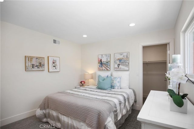 carpeted bedroom featuring a walk in closet and a closet