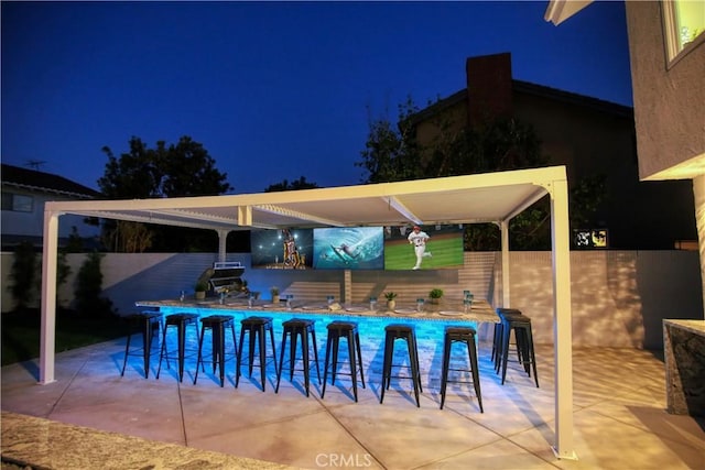 view of swimming pool featuring exterior bar, a patio area, and a grill