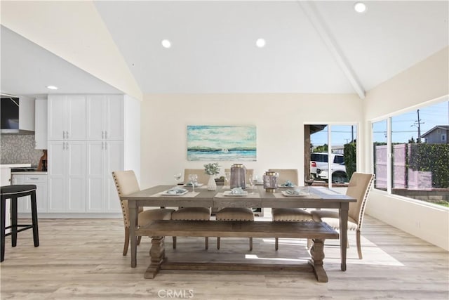 dining space featuring vaulted ceiling with beams and light hardwood / wood-style floors