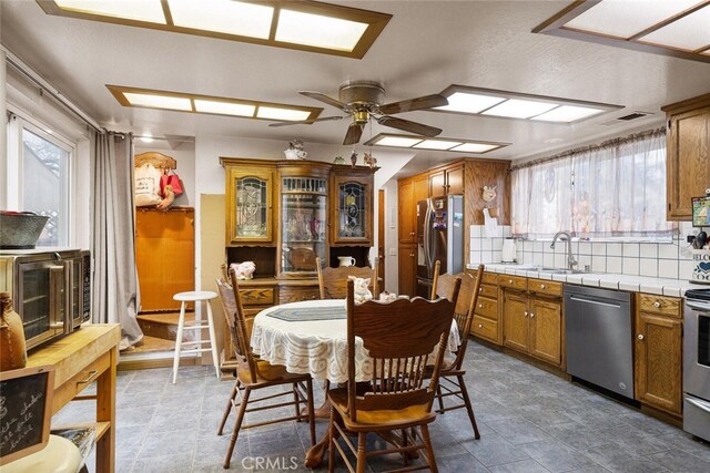 dining space featuring ceiling fan, sink, and a healthy amount of sunlight