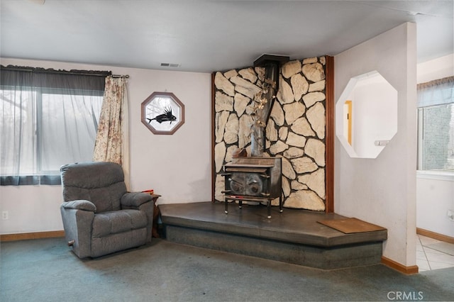 sitting room featuring light colored carpet and a wood stove