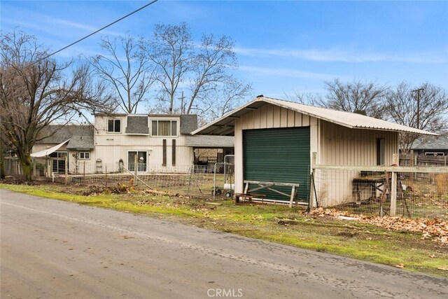 view of front of house with a garage and an outbuilding