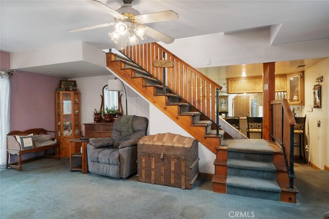 staircase with ceiling fan and carpet