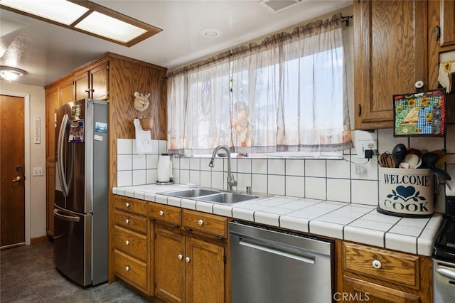 kitchen with tasteful backsplash, appliances with stainless steel finishes, sink, and plenty of natural light