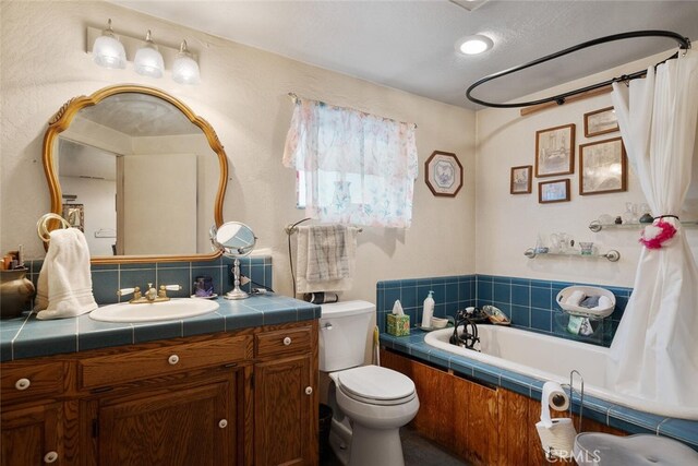 bathroom featuring toilet, tiled bath, tasteful backsplash, and vanity