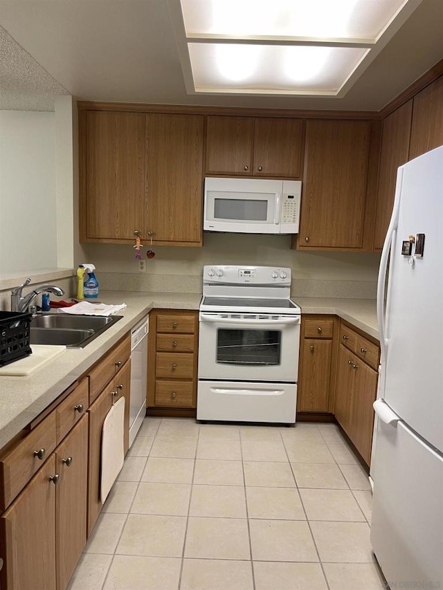 kitchen with light tile patterned floors, sink, and white appliances