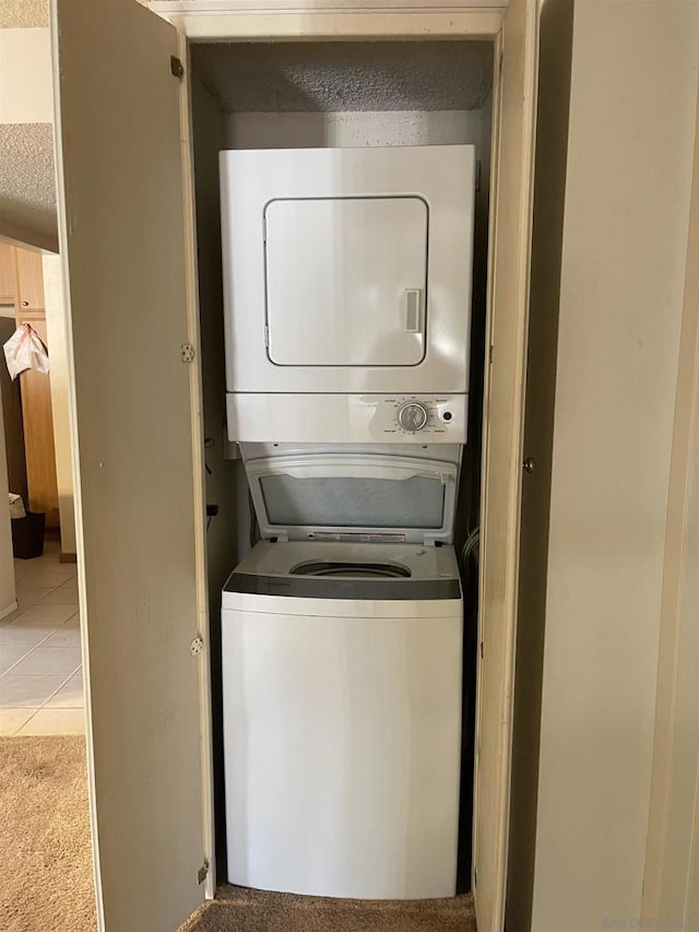 laundry room featuring light carpet and stacked washer and clothes dryer