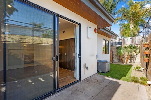 doorway to property with central AC and a patio