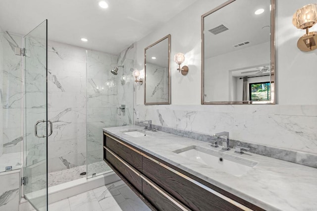 bathroom featuring walk in shower, vanity, and tile walls