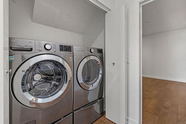 washroom with washing machine and dryer and hardwood / wood-style floors