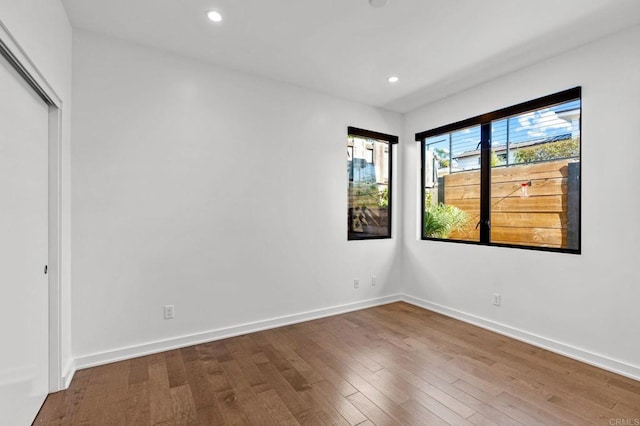 unfurnished room with hardwood / wood-style flooring