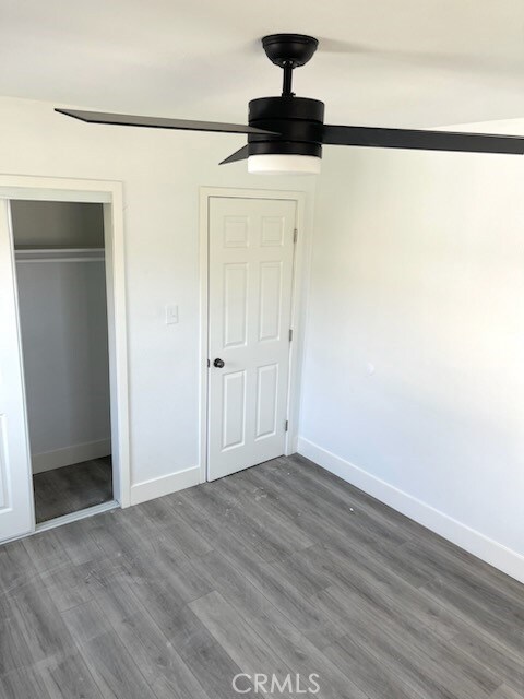 unfurnished bedroom with ceiling fan, hardwood / wood-style floors, and a closet