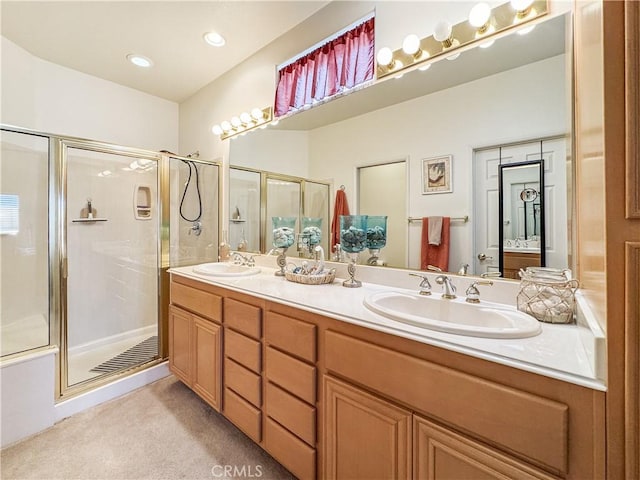 bathroom featuring a shower with shower door and vanity