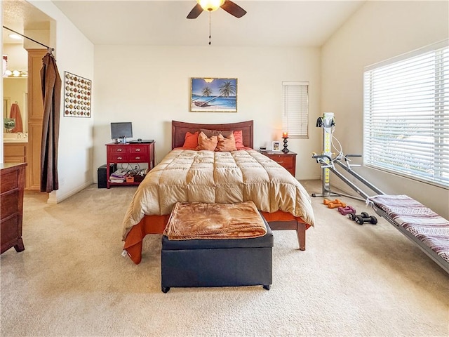 bedroom featuring ceiling fan, ensuite bath, and light carpet