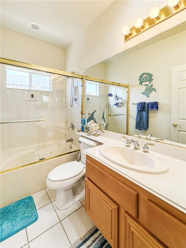 full bathroom featuring toilet, vanity, tile patterned flooring, and shower / bath combination with glass door