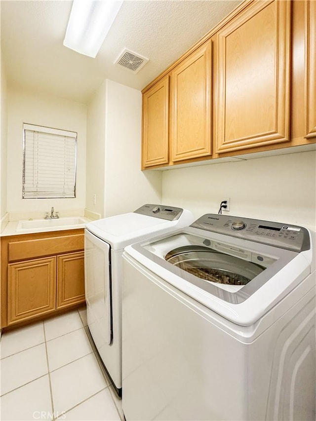 laundry room with cabinets, separate washer and dryer, light tile patterned flooring, and sink