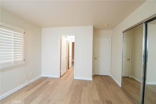 unfurnished bedroom featuring a closet and light wood-type flooring