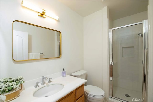 bathroom with vanity, a shower with shower door, and toilet