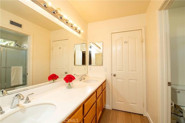 bathroom featuring an enclosed shower, wood-type flooring, vanity, and toilet