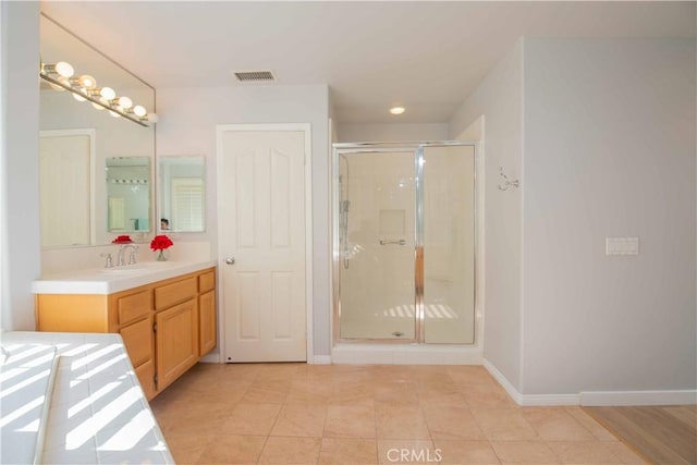 bathroom featuring tile patterned flooring, vanity, and walk in shower