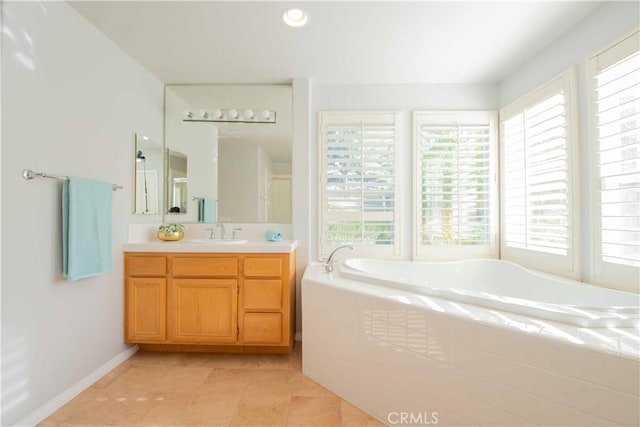 bathroom with tile patterned floors, vanity, and tiled tub