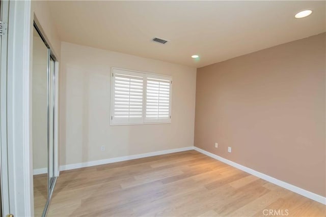 unfurnished bedroom with a closet and light wood-type flooring