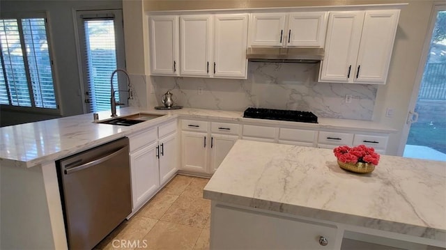 kitchen featuring sink, white cabinetry, light stone countertops, decorative backsplash, and stainless steel dishwasher