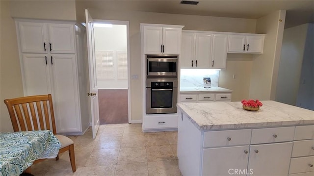 kitchen featuring a kitchen island, white cabinets, and appliances with stainless steel finishes