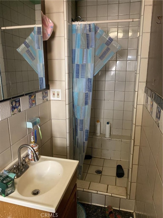 bathroom with tile walls, walk in shower, and vanity