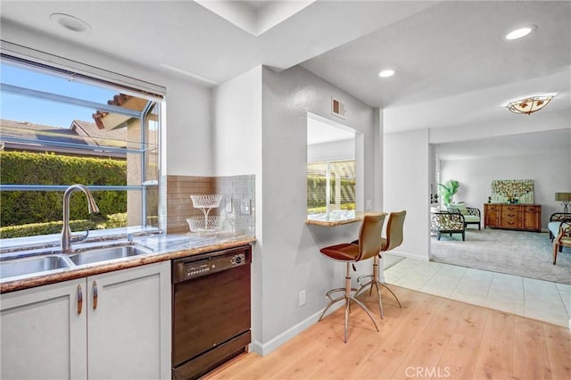 kitchen featuring a sink, visible vents, white cabinets, light countertops, and dishwasher