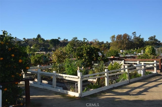 exterior space featuring a garden and fence