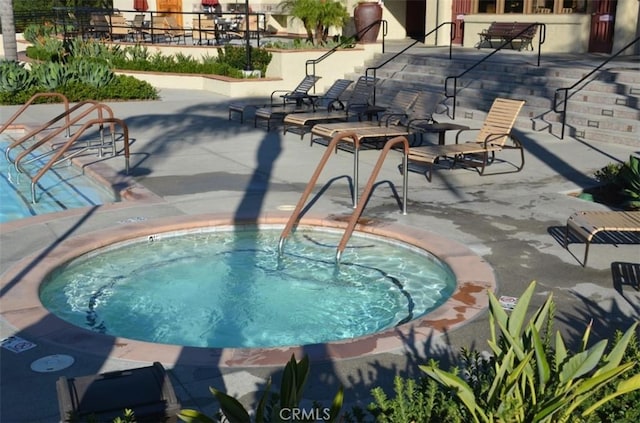 view of pool with a community hot tub and a patio area