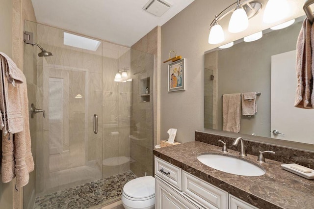 bathroom featuring toilet, an enclosed shower, and vanity