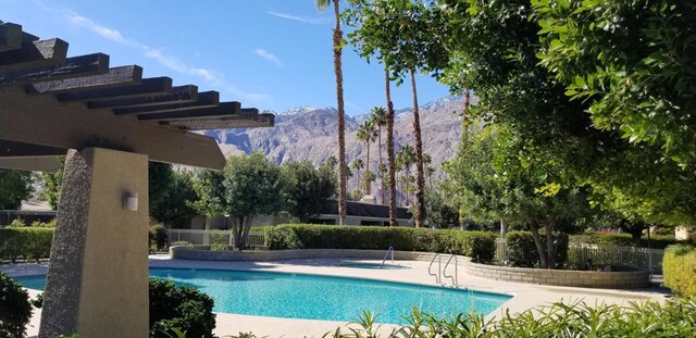 view of swimming pool featuring a mountain view and a patio