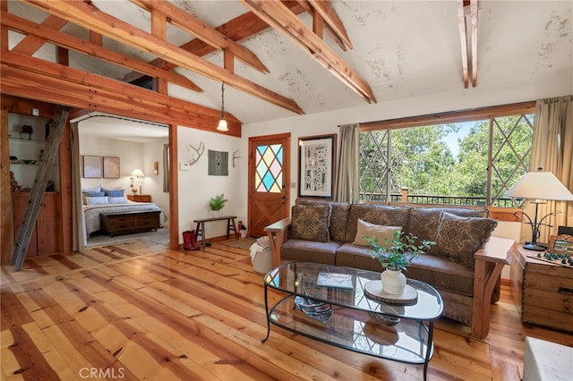 living room with vaulted ceiling with beams and light hardwood / wood-style flooring