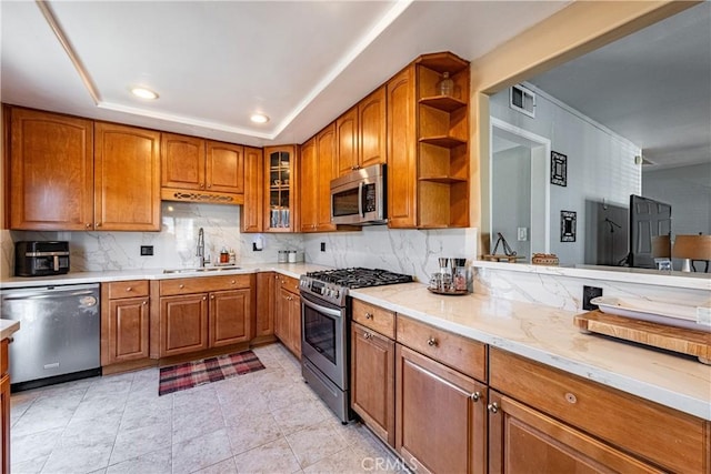 kitchen with a raised ceiling, decorative backsplash, sink, appliances with stainless steel finishes, and light tile patterned floors