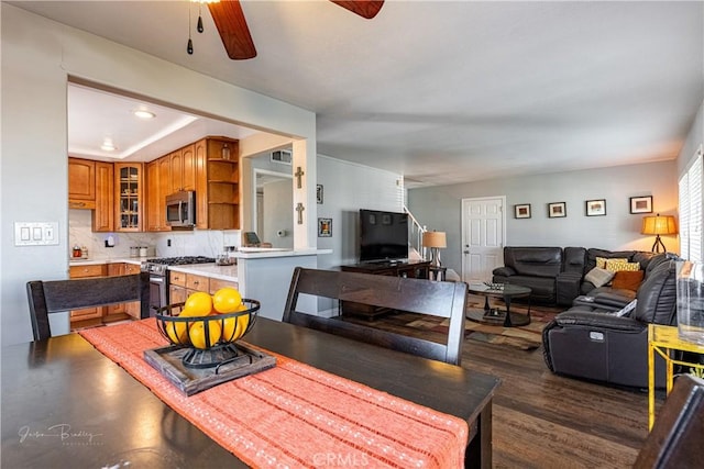 dining area with ceiling fan and dark hardwood / wood-style floors