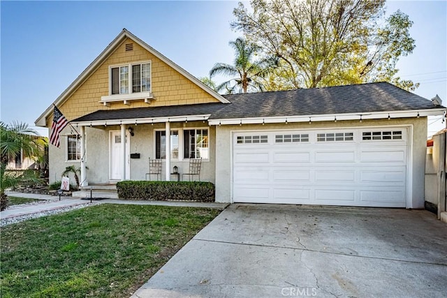 view of front of property with a front yard, a garage, and a porch