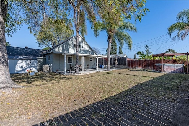 back of property with a patio area and a yard