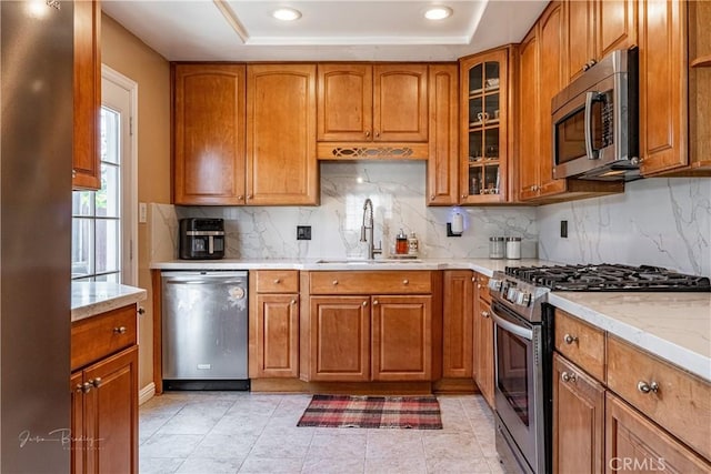 kitchen with decorative backsplash, sink, a raised ceiling, and stainless steel appliances