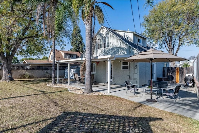 rear view of house featuring a yard and a patio