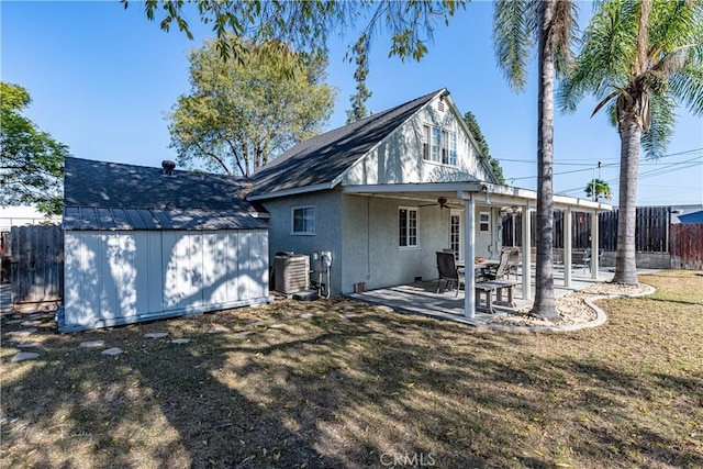 rear view of house featuring a patio area, a shed, ceiling fan, a yard, and central air condition unit