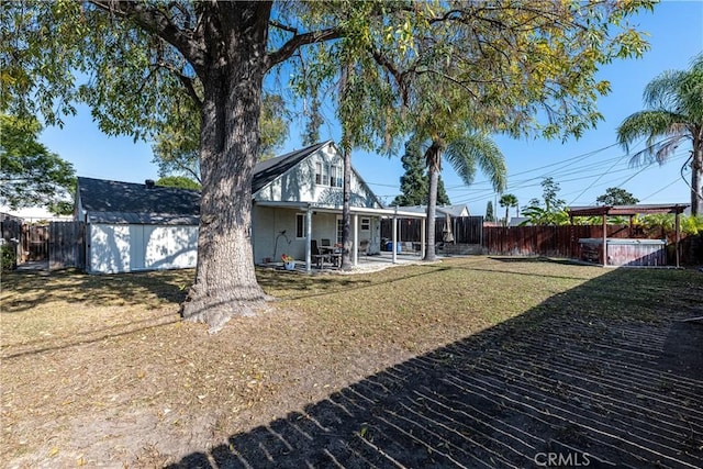 back of property featuring a patio area, a hot tub, a storage shed, and a yard