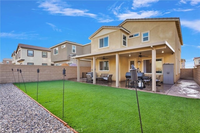 back of property with an outdoor hangout area, ceiling fan, a patio area, and a lawn